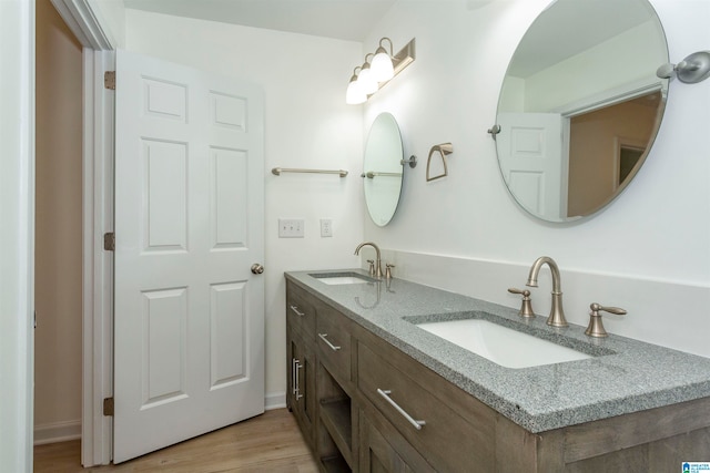 bathroom with wood-type flooring and double sink vanity