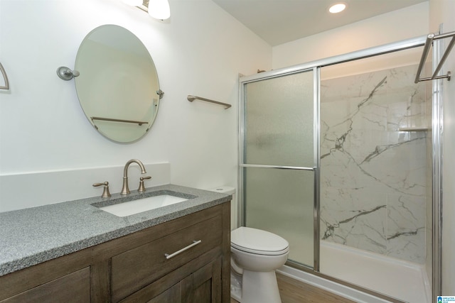 bathroom featuring a shower with shower door, vanity, hardwood / wood-style floors, and toilet