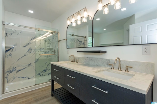 bathroom with double vanity, walk in shower, and wood-type flooring