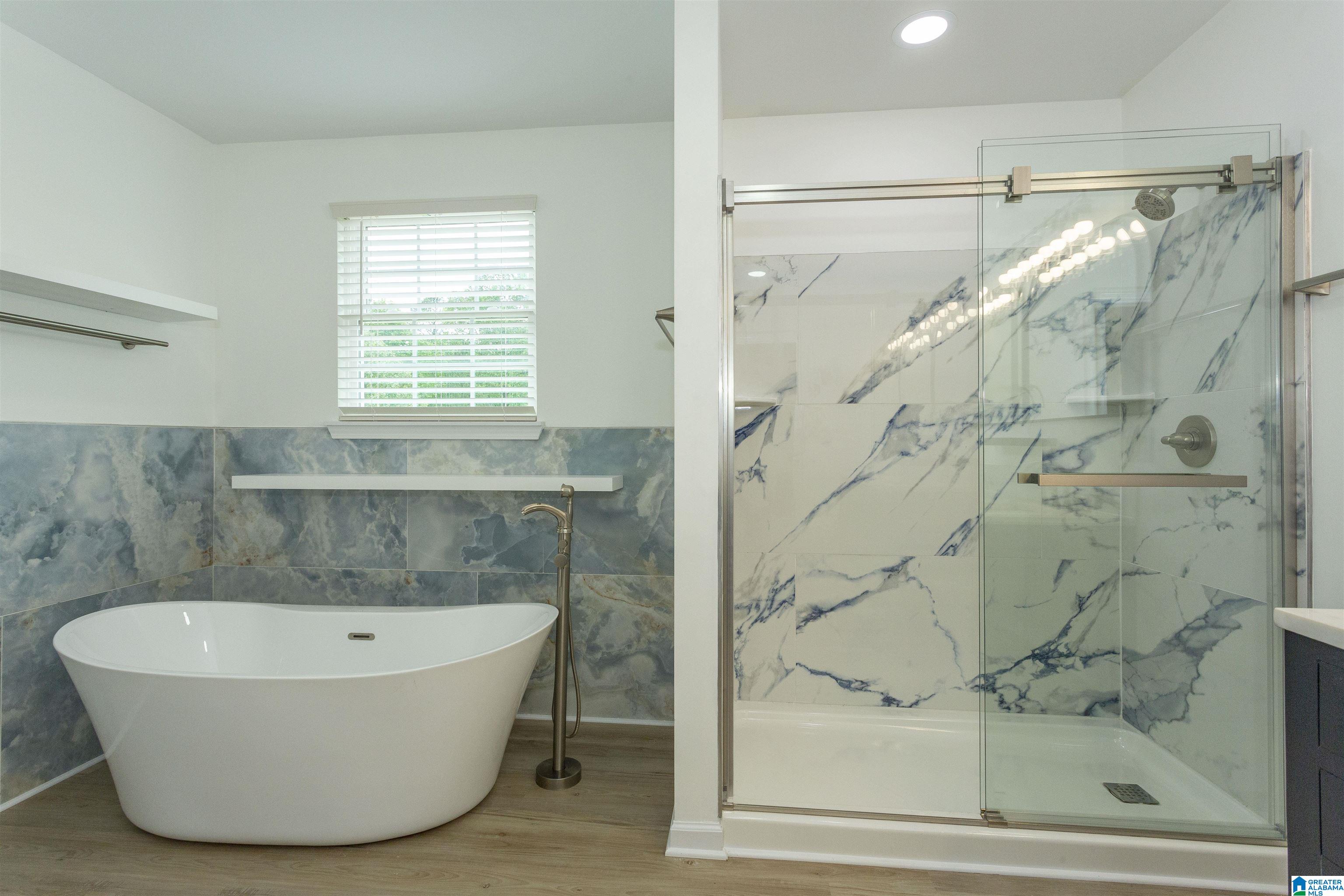 bathroom with a shower with door, vanity, tile walls, and wood-type flooring