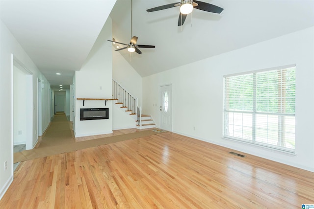 unfurnished living room featuring high vaulted ceiling, light wood-type flooring, and ceiling fan