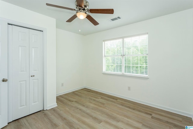 unfurnished bedroom with ceiling fan, light hardwood / wood-style floors, and a closet