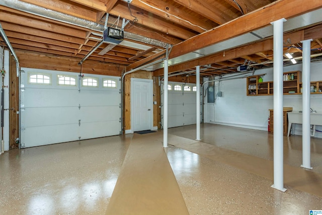 garage with a garage door opener and electric panel