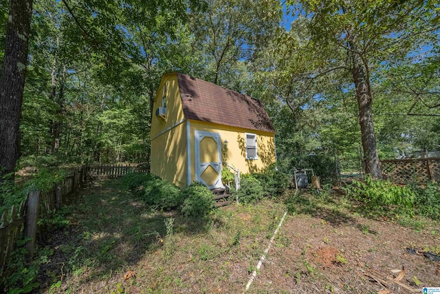 view of side of home with a storage shed