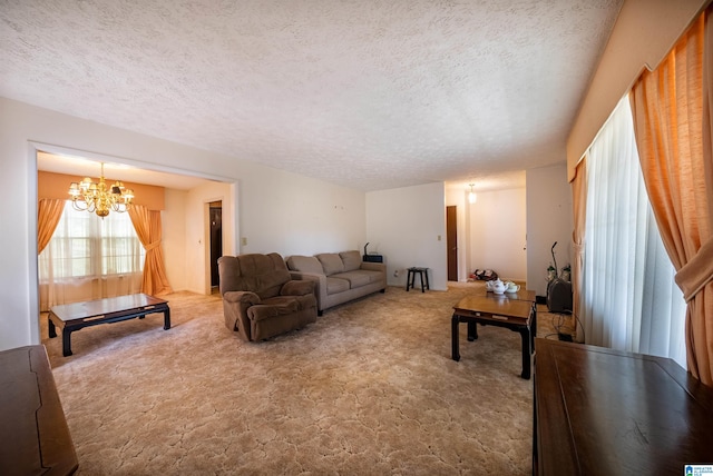 living room featuring a textured ceiling, a chandelier, and carpet