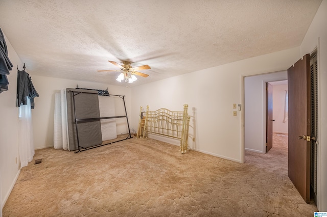 carpeted spare room featuring ceiling fan and a textured ceiling