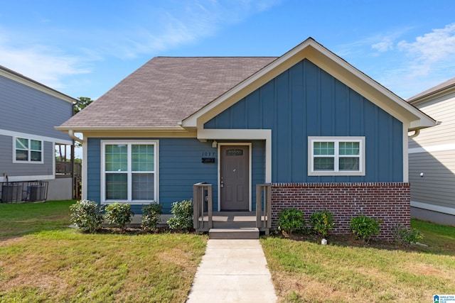 bungalow-style house with central AC and a front lawn