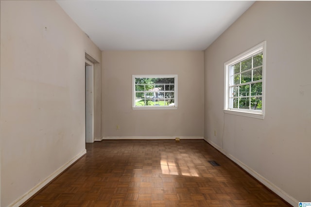 spare room featuring dark parquet floors