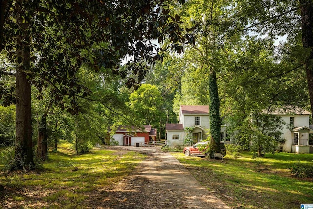 view of front facade featuring a garage, an outbuilding, and a front yard