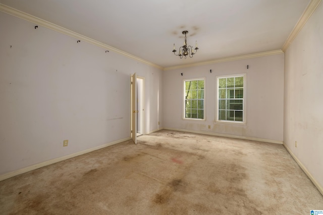 carpeted spare room featuring ornamental molding and an inviting chandelier