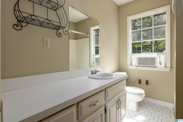 bathroom with cooling unit, vanity, tile patterned flooring, and toilet