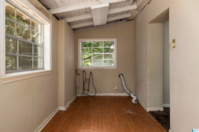 empty room featuring vaulted ceiling with beams, wooden ceiling, and hardwood / wood-style flooring