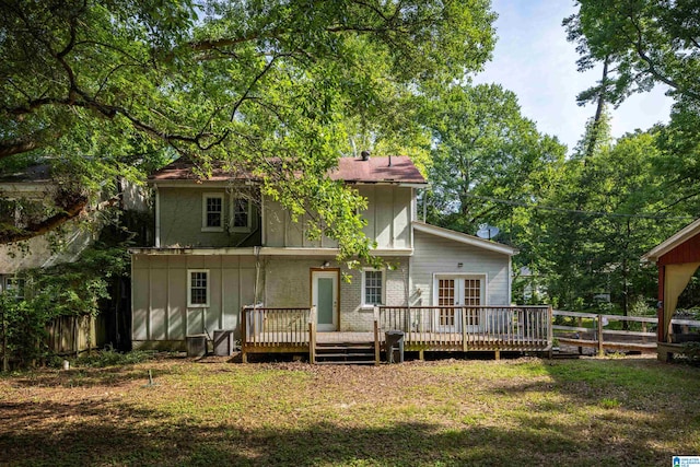 rear view of house with a lawn and a wooden deck