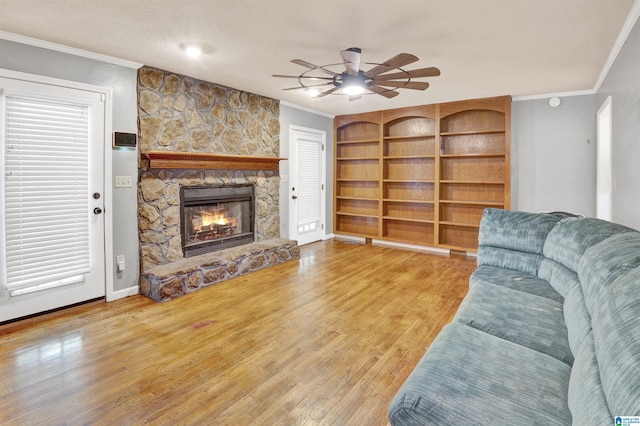 living room with crown molding, wood-type flooring, and a fireplace