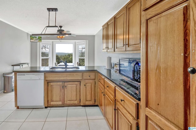 kitchen featuring sink, hanging light fixtures, light tile patterned floors, white dishwasher, and kitchen peninsula