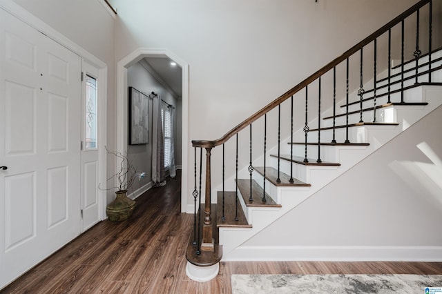 entrance foyer with ornamental molding and dark hardwood / wood-style floors