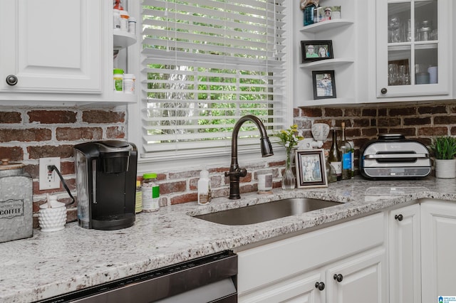 kitchen featuring sink, light stone countertops, white cabinets, and dishwasher