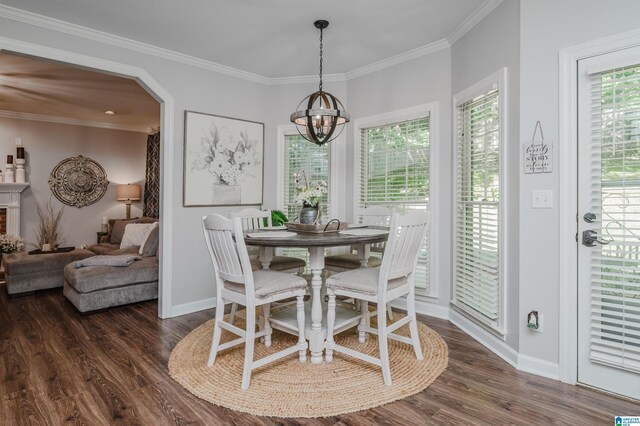 dining area with an inviting chandelier, crown molding, and dark hardwood / wood-style flooring