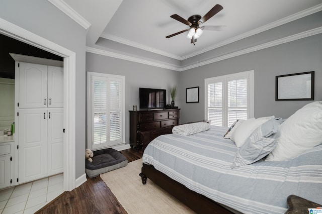 bedroom featuring multiple windows, hardwood / wood-style flooring, crown molding, and ceiling fan