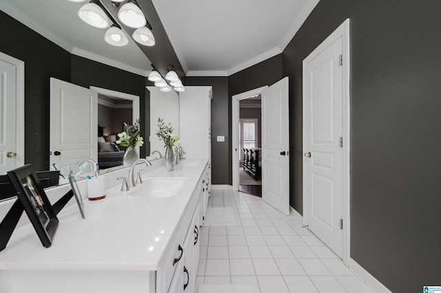 bathroom with tile patterned flooring, a notable chandelier, ornamental molding, and double sink vanity