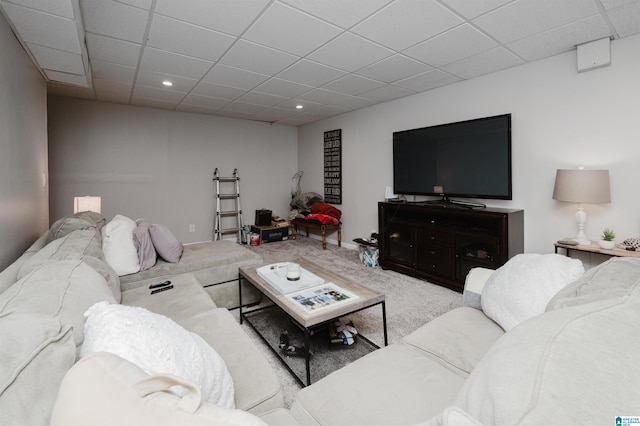 living room with a paneled ceiling and carpet