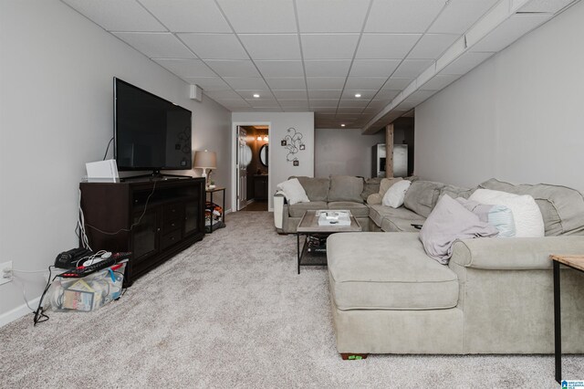 carpeted living room featuring a drop ceiling