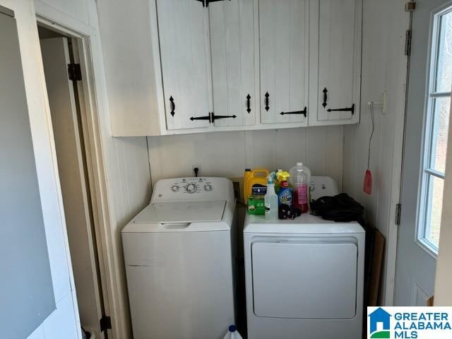 laundry area with separate washer and dryer and cabinets