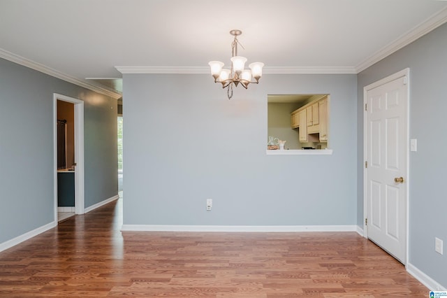 empty room with an inviting chandelier, hardwood / wood-style flooring, and ornamental molding