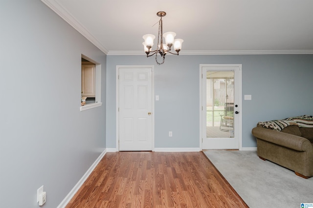 doorway featuring crown molding, an inviting chandelier, and hardwood / wood-style floors