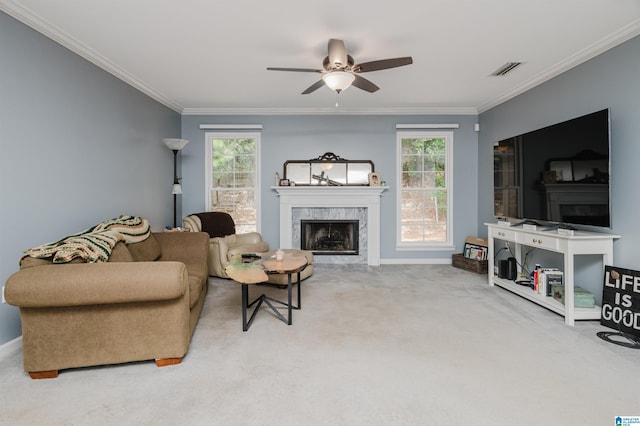 carpeted living room with crown molding, a premium fireplace, and ceiling fan