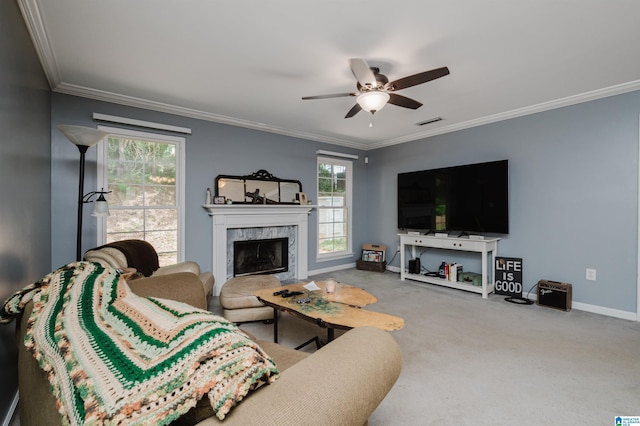 carpeted living room with ceiling fan, ornamental molding, and a premium fireplace