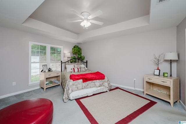 bedroom featuring a tray ceiling, ceiling fan, and carpet flooring