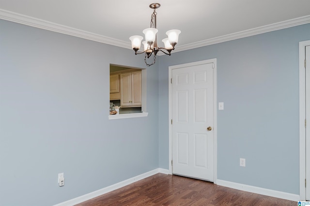 empty room featuring an inviting chandelier, ornamental molding, and dark hardwood / wood-style floors