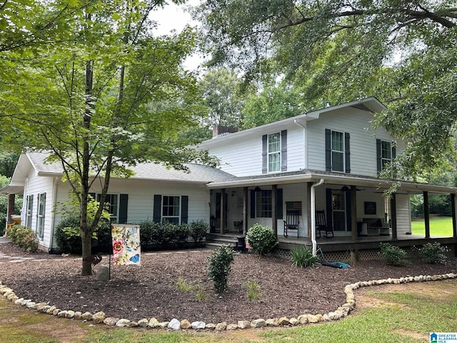 country-style home featuring a chimney and covered porch