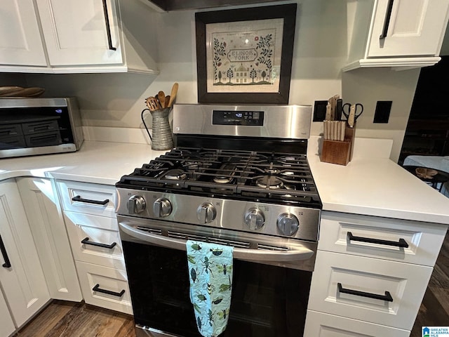 kitchen featuring white cabinets, stainless steel range with gas stovetop, a toaster, light countertops, and dark wood-type flooring