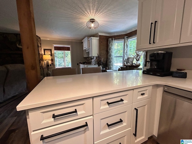 kitchen featuring a peninsula, light countertops, stainless steel dishwasher, and white cabinetry