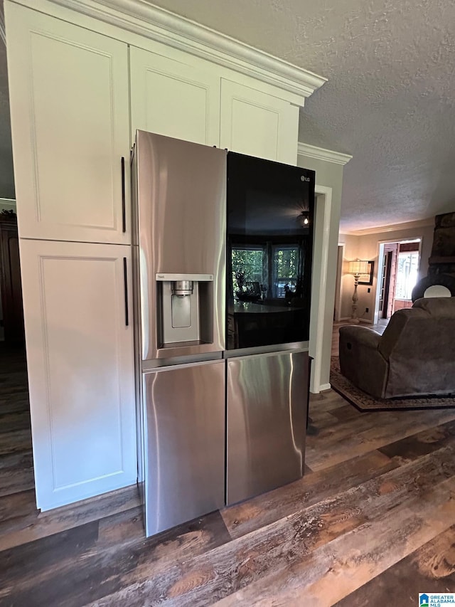kitchen featuring dark wood finished floors, a textured ceiling, stainless steel refrigerator with ice dispenser, and ornamental molding