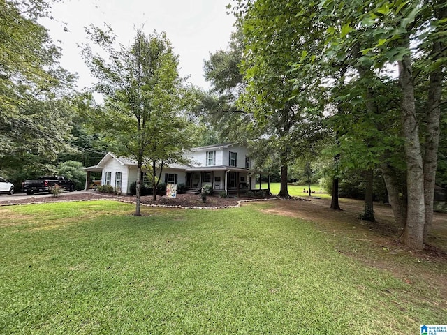 traditional home featuring a porch, driveway, and a front yard