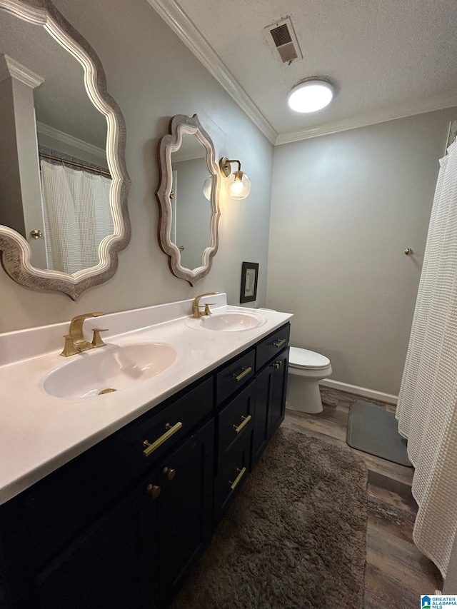 full bathroom with wood finished floors, visible vents, ornamental molding, and a sink