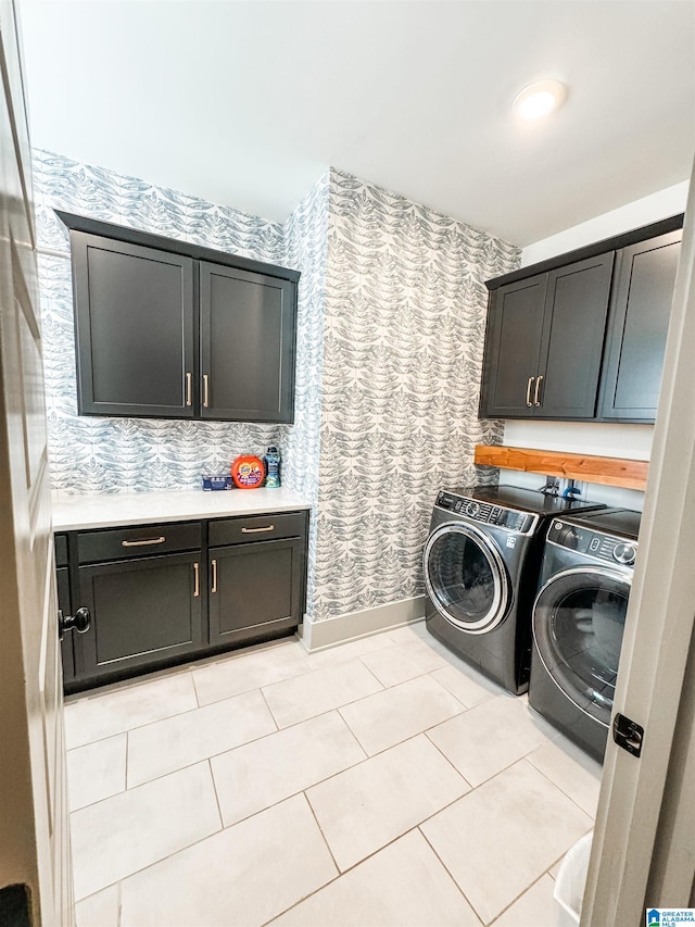 washroom featuring washer and clothes dryer, cabinets, and light tile patterned flooring