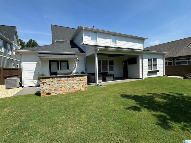 rear view of property featuring a lawn, ceiling fan, central AC, a patio, and an outdoor living space