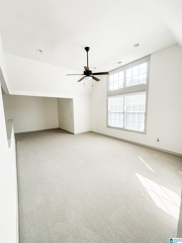 additional living space featuring light carpet, lofted ceiling, and ceiling fan