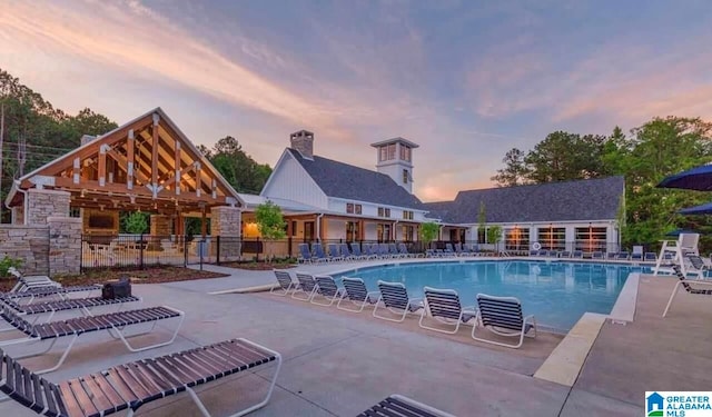 pool at dusk with a gazebo and a patio