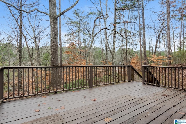 wooden terrace featuring a forest view