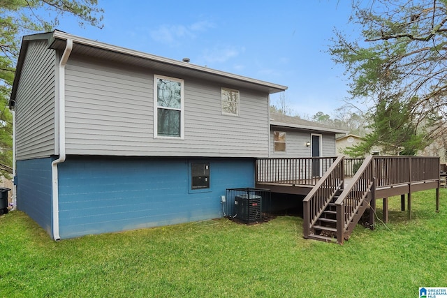 back of property with a wooden deck, stairs, central AC unit, and a yard