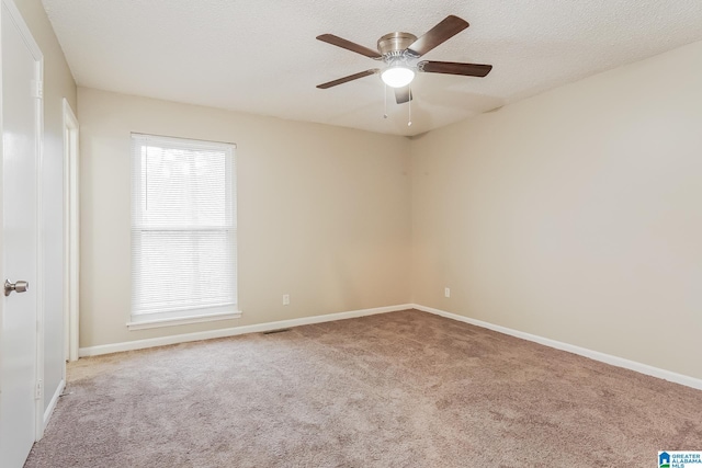 spare room featuring carpet flooring, ceiling fan, a textured ceiling, and baseboards