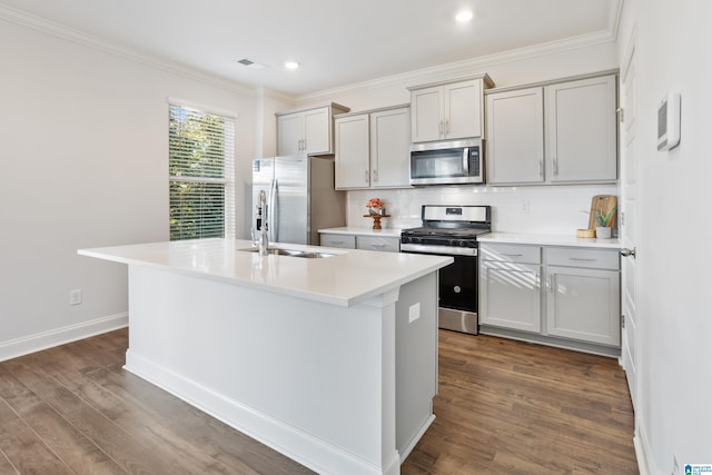 kitchen featuring decorative backsplash, appliances with stainless steel finishes, dark hardwood / wood-style floors, and an island with sink