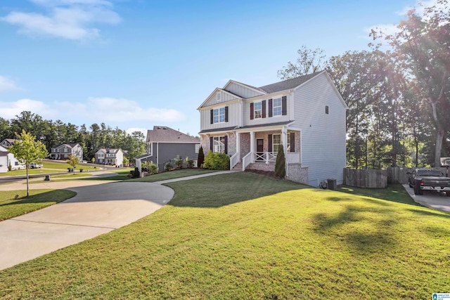 view of front of property with covered porch, fence, concrete driveway, board and batten siding, and a front yard