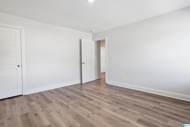 unfurnished room featuring light wood finished floors and baseboards