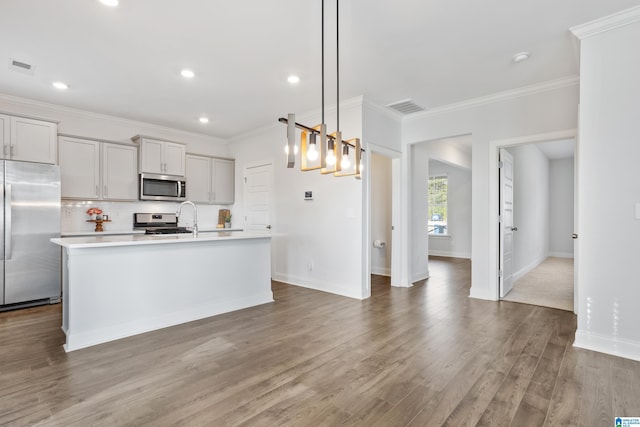 kitchen with a kitchen island with sink, gray cabinetry, stainless steel appliances, hanging light fixtures, and light countertops